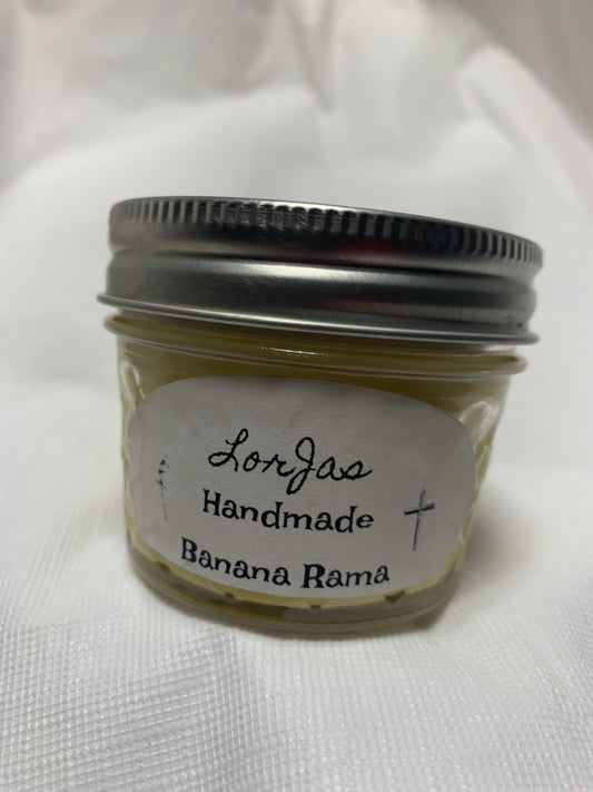 A small jar of LorJas Handmade 'Banana Rama' scented candle with a label on a white background