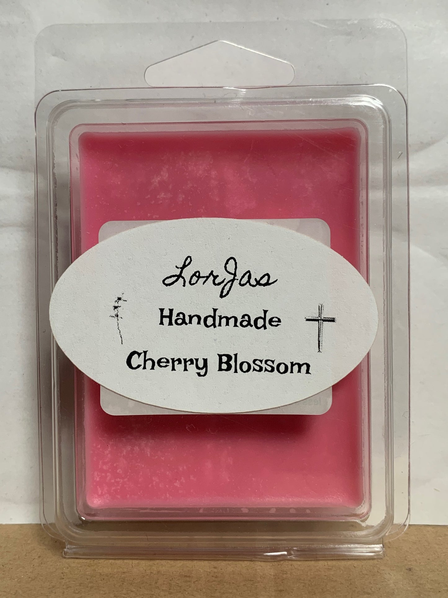 Pink wax melt in a clear container with a 'Handmade Cherry Blossom' label.