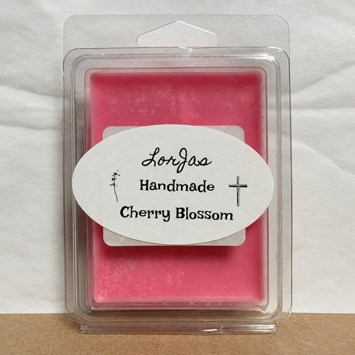 Pink wax melt in a clamshell container with a LorJas Handmade 'Cherry Blossom' brand label.