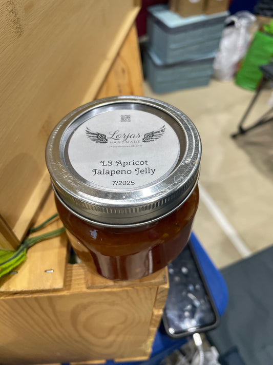 Jar of LorJas Handmade 'Apricot Jalapeño' pepper jelly at market on a wooden display box