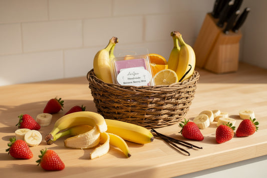 Organic soy scented melt 'LorJas Handmade Banana Berry Blitz' in basket with bananas, citrus, vanilla bean, and coconuts on countertop