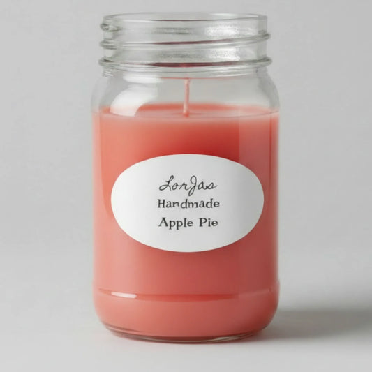 A LorJas Handmade Apple Pie scented candle in a clear glass mason jar, featuring deep red wax and a white oval label with black text, set against a neutral light gray background.