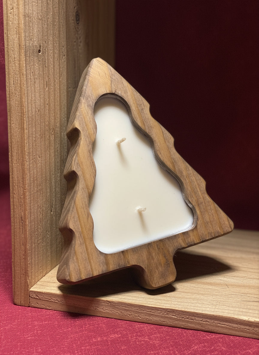 Wooden tree-shaped mold filled with a white organic soy candle pitched at an angle in a wood shelf with red fabric underneath