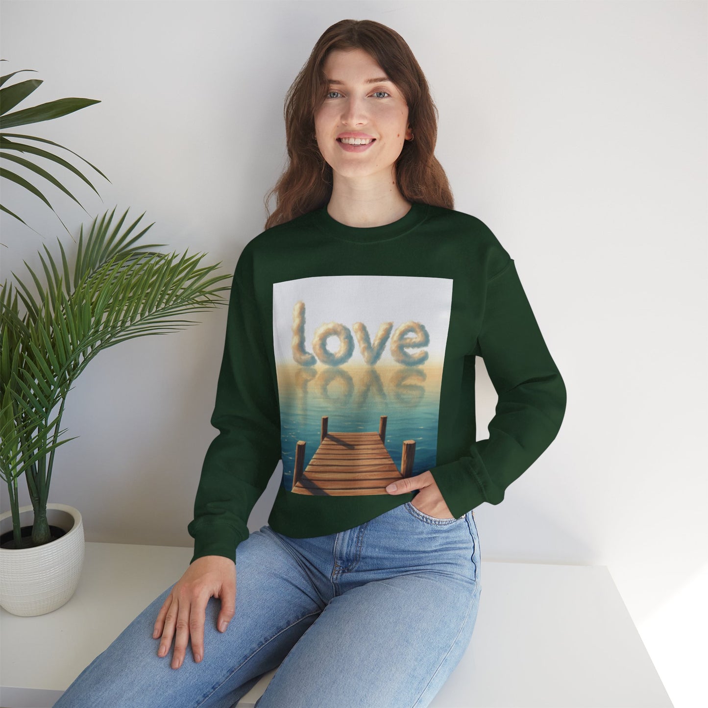 Person wearing a green sweatshirt with a 'love' graphic design sitting on a white surface.