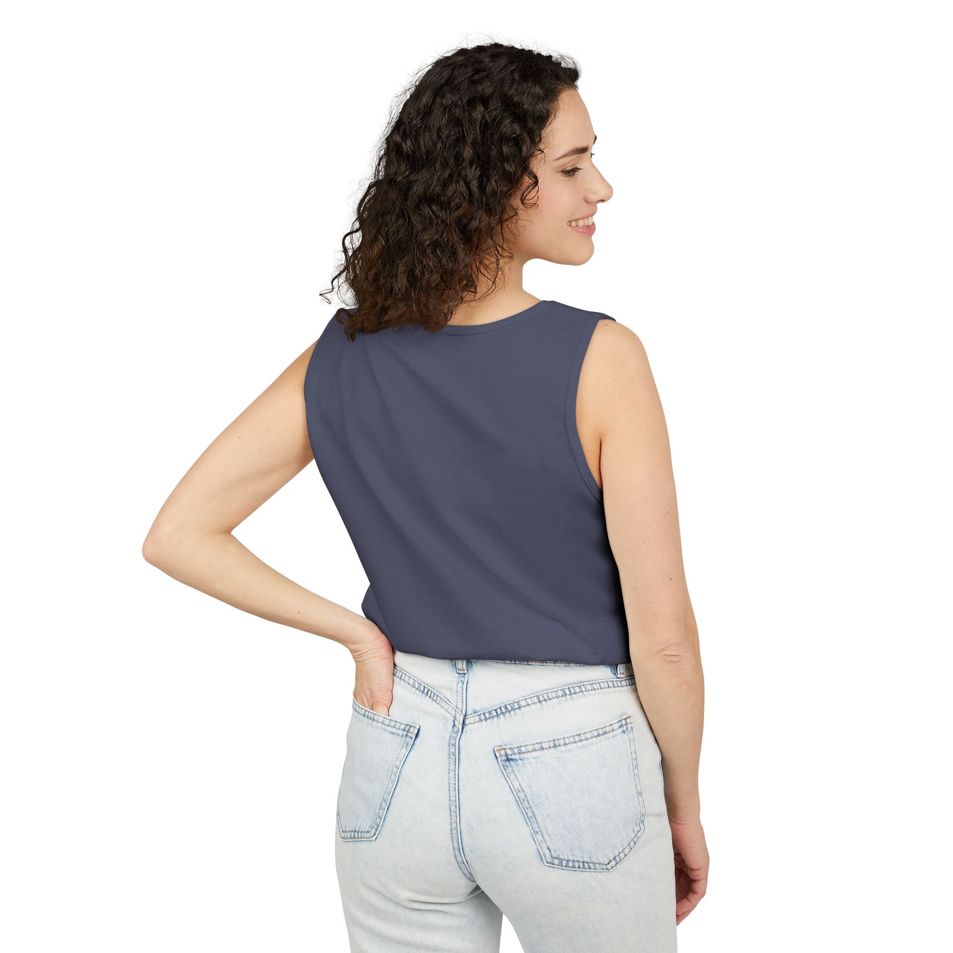 Woman wearing a sleeveless gray top and light blue jeans on a white background