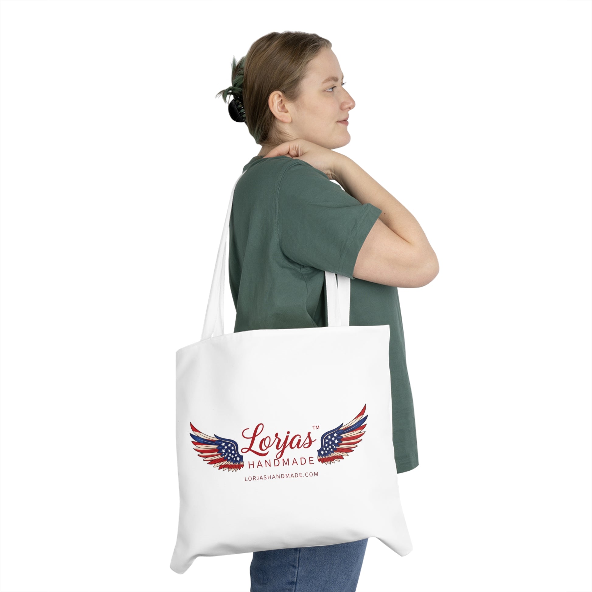 Woman holding a tote bag with 'LorJas Handmade' branded logo on a white background