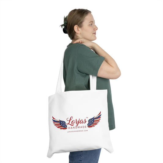 Woman holding a tote bag with 'LorJas Handmade' branded logo on a white background