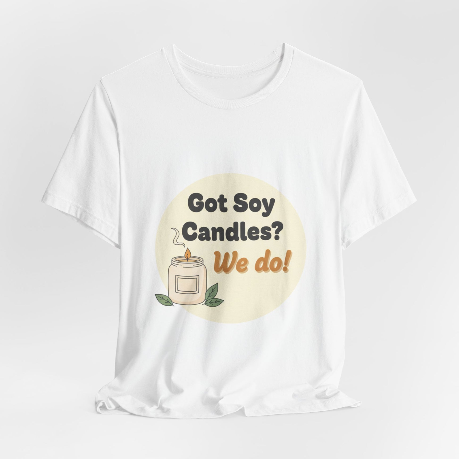 White t-shirt with a graphic design of a candle and text 'Got Soy Candles? We do!' on a light gray background.