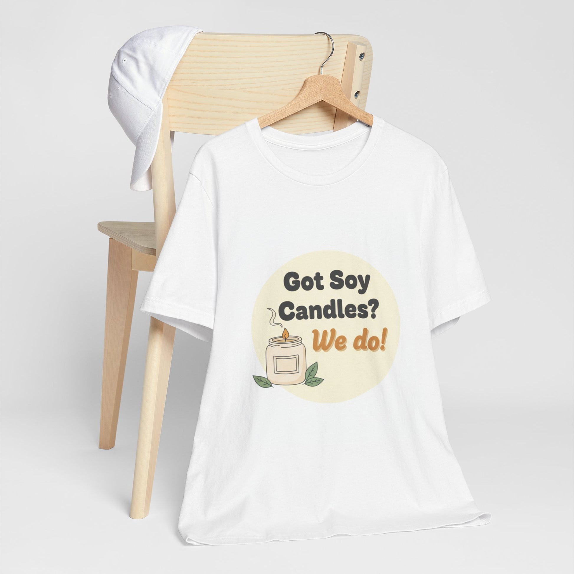 White t-shirt with 'Got Soy Candles? We do!' graphic on a wooden chair against a white background