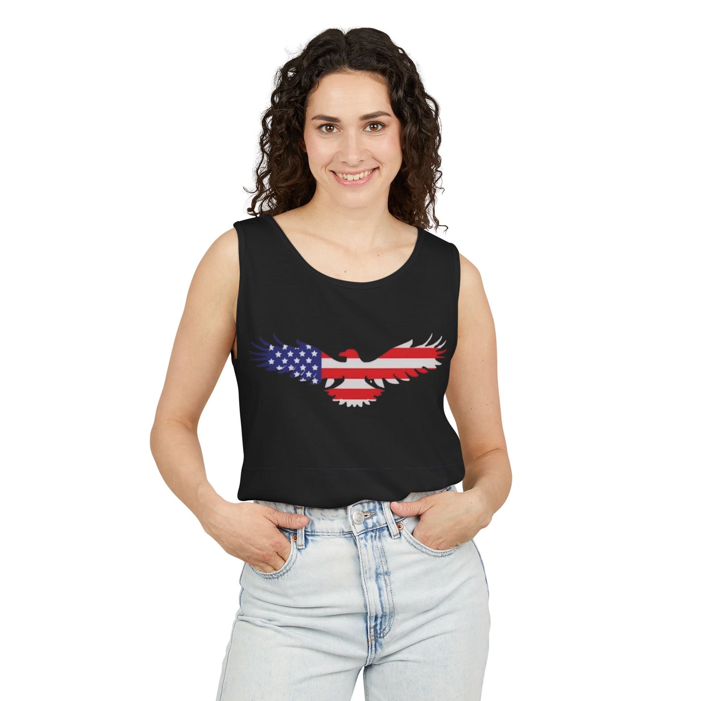 A woman modeling a black sleeveless crop top with a graphic of an eagle filled with the American flag pattern, paired with light-wash jeans against a plain white background.
