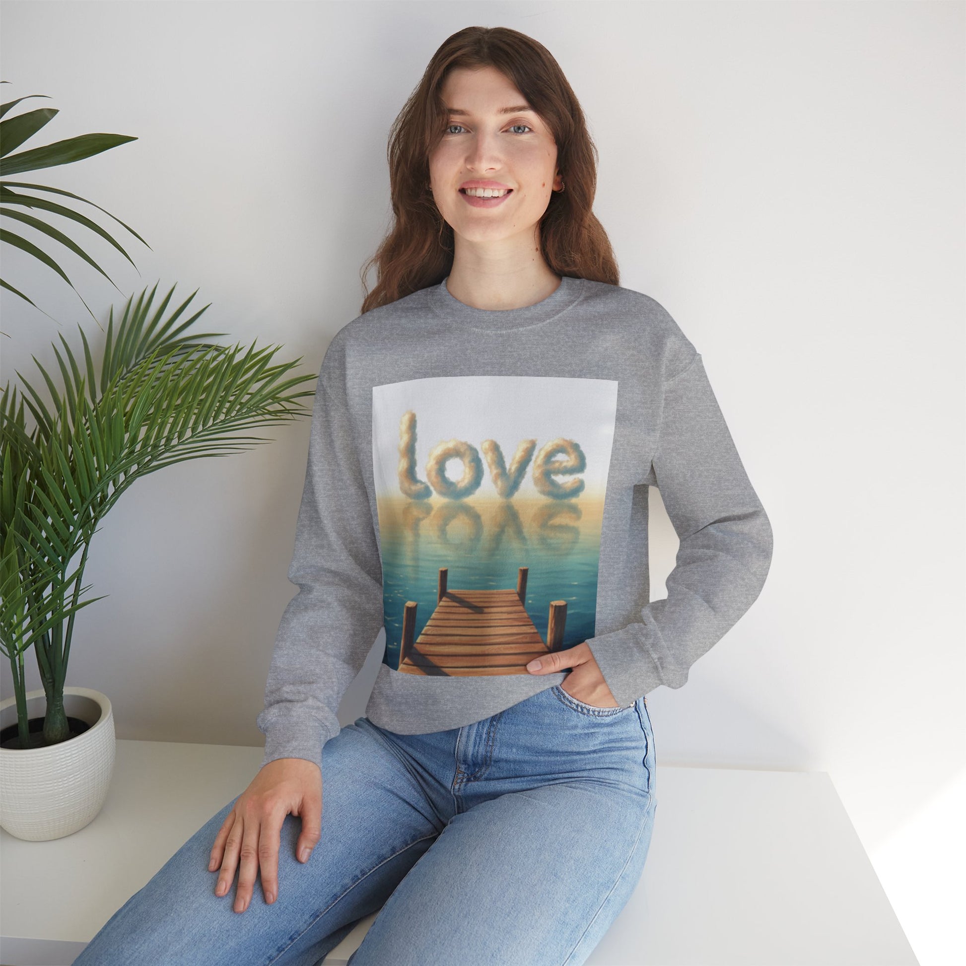 Woman wearing a gray sweatshirt with a 'love' graphic design sitting on a white couch.