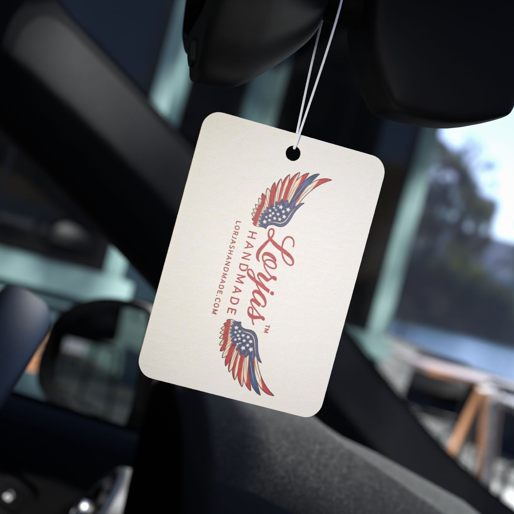 Car air freshener tag with 'LorJas Handmade' branding hanging from a car's rearview mirror.