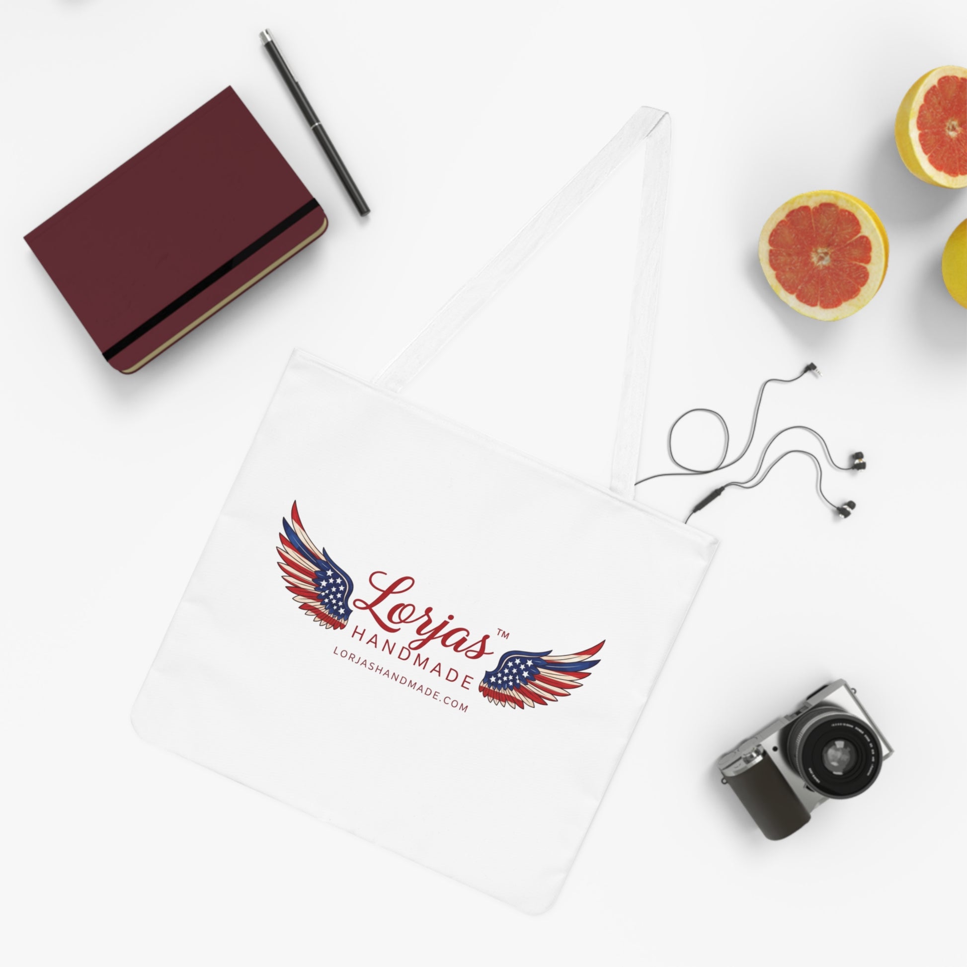 'Lorjas Handmade' branded tote bage surrounded by various items on a white surface.