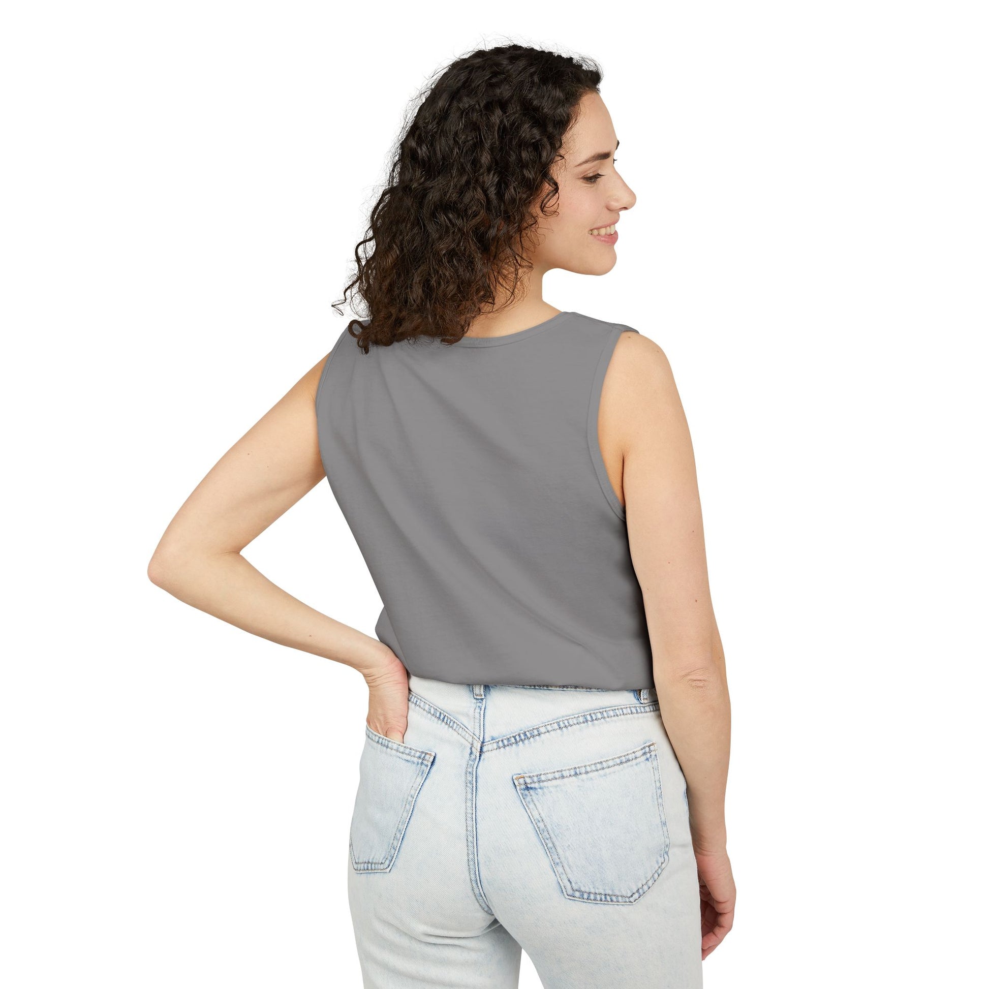 Woman wearing a gray sleeveless top and light blue jeans on a white background