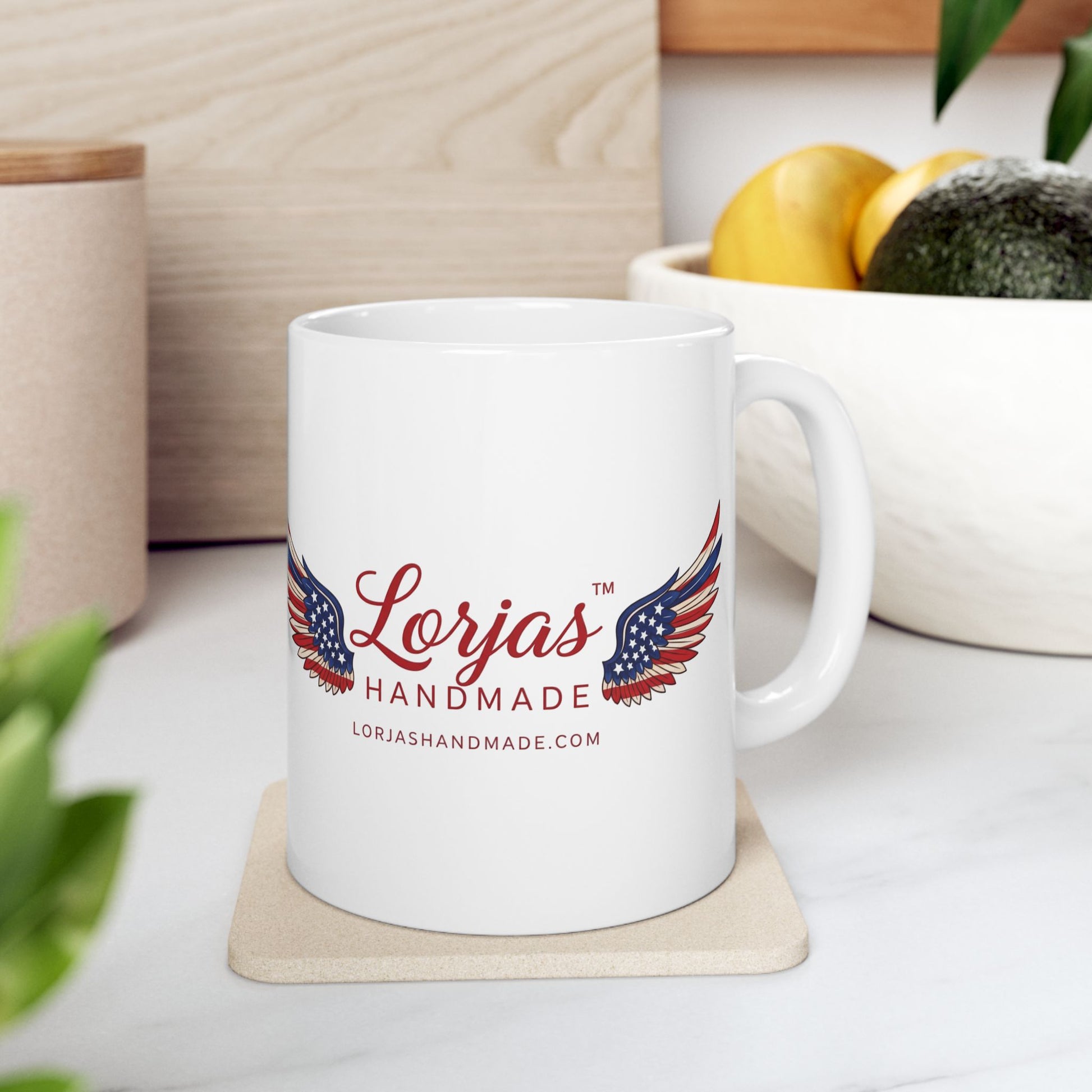 White mug with 'Lorjas Handmade' logo on a coaster, surrounded by kitchen items.