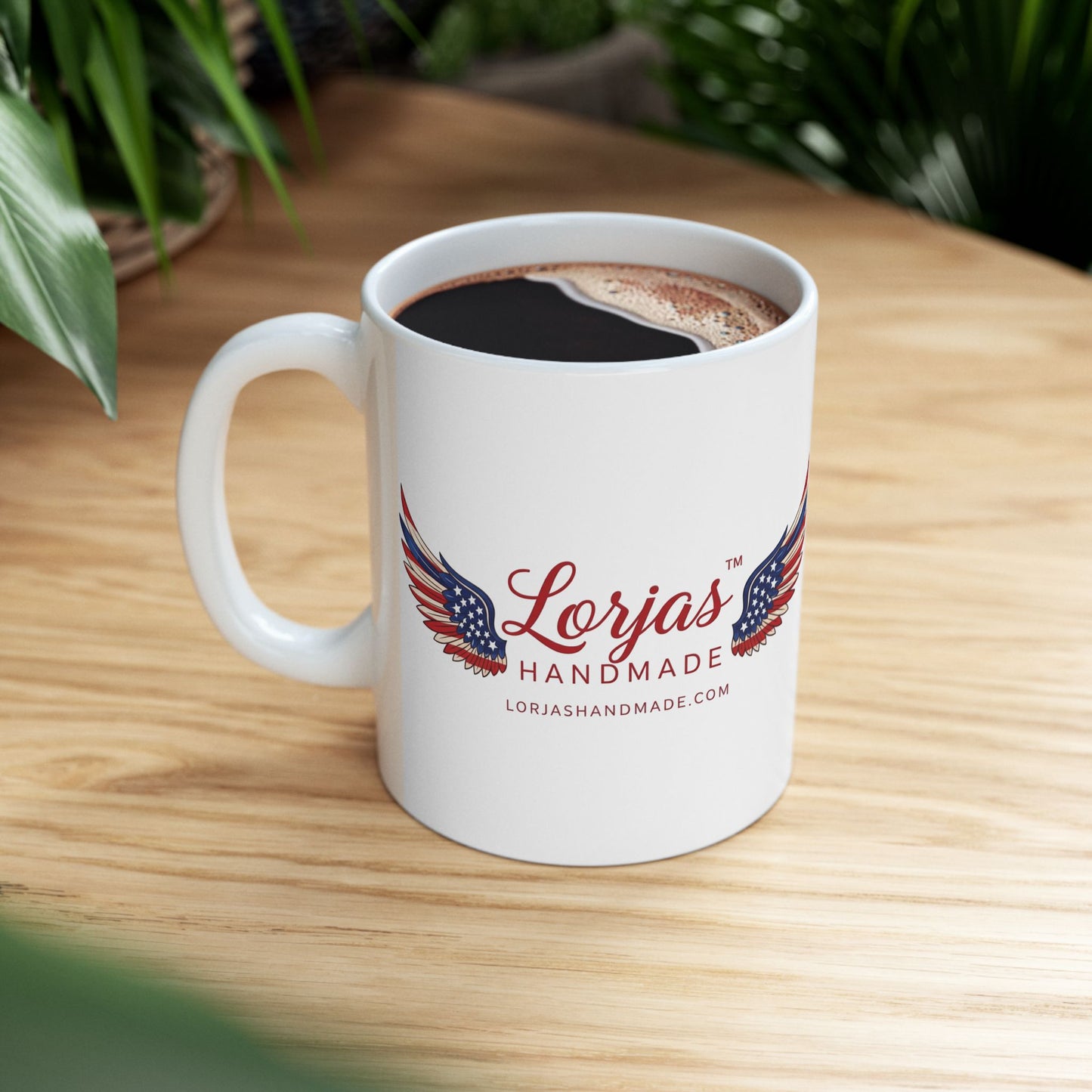 White mug with 'Lorjas Handmade' logo on a wooden table