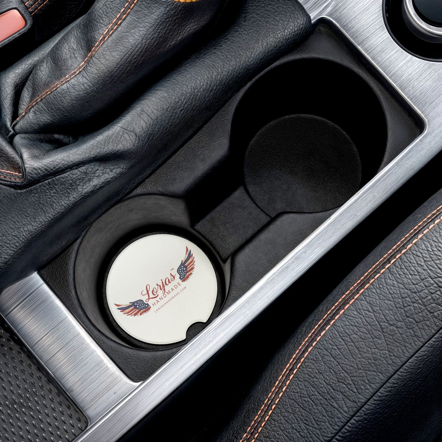 Car cup holder with a 'Lorjas Handmade' branded coaster inside