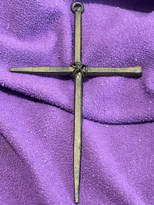 Bronze cross on a purple fabric background