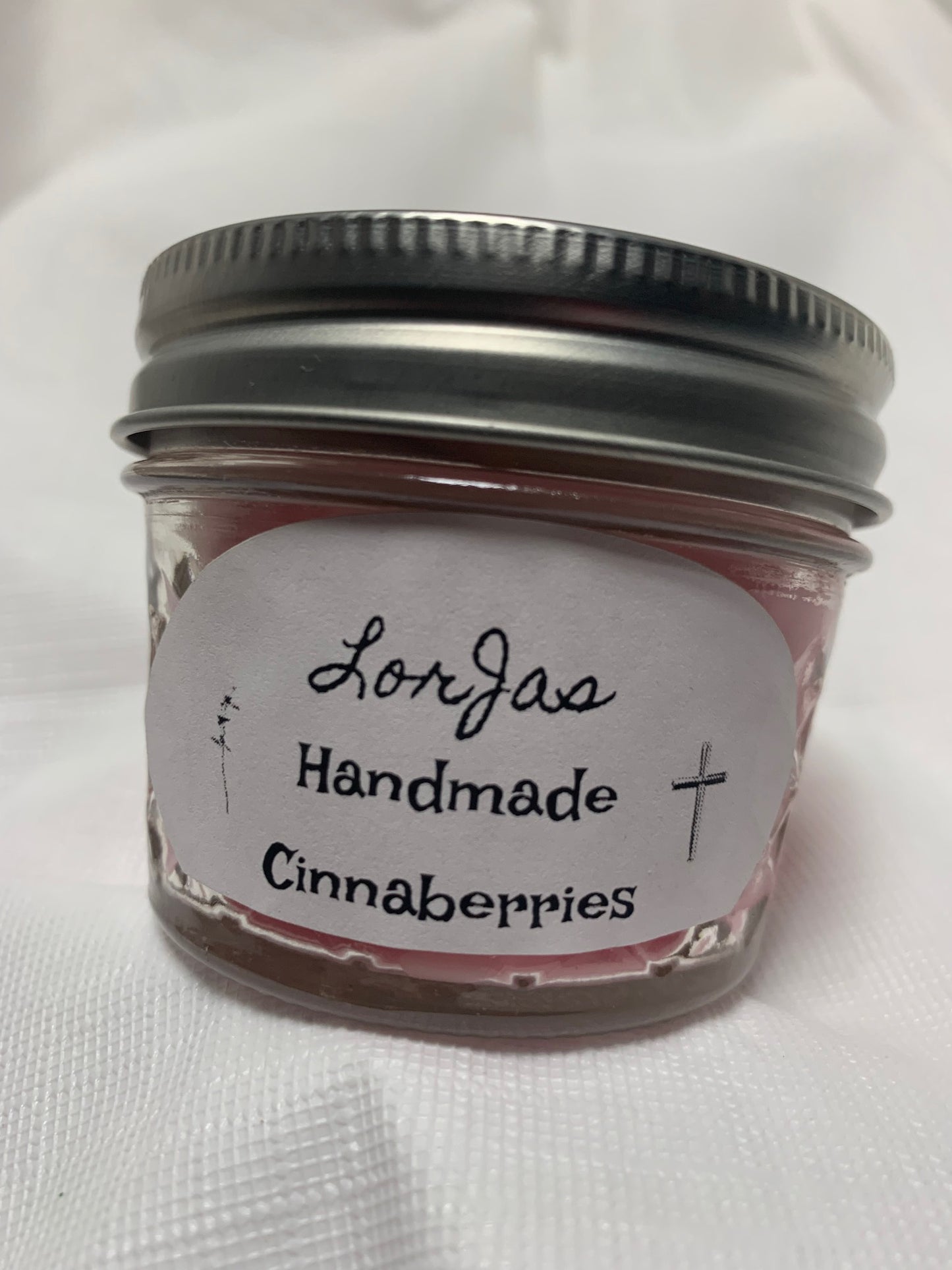 Jar of LorJas Handmade 'Cinnaberries' scented organic soy candle with a label on a white background