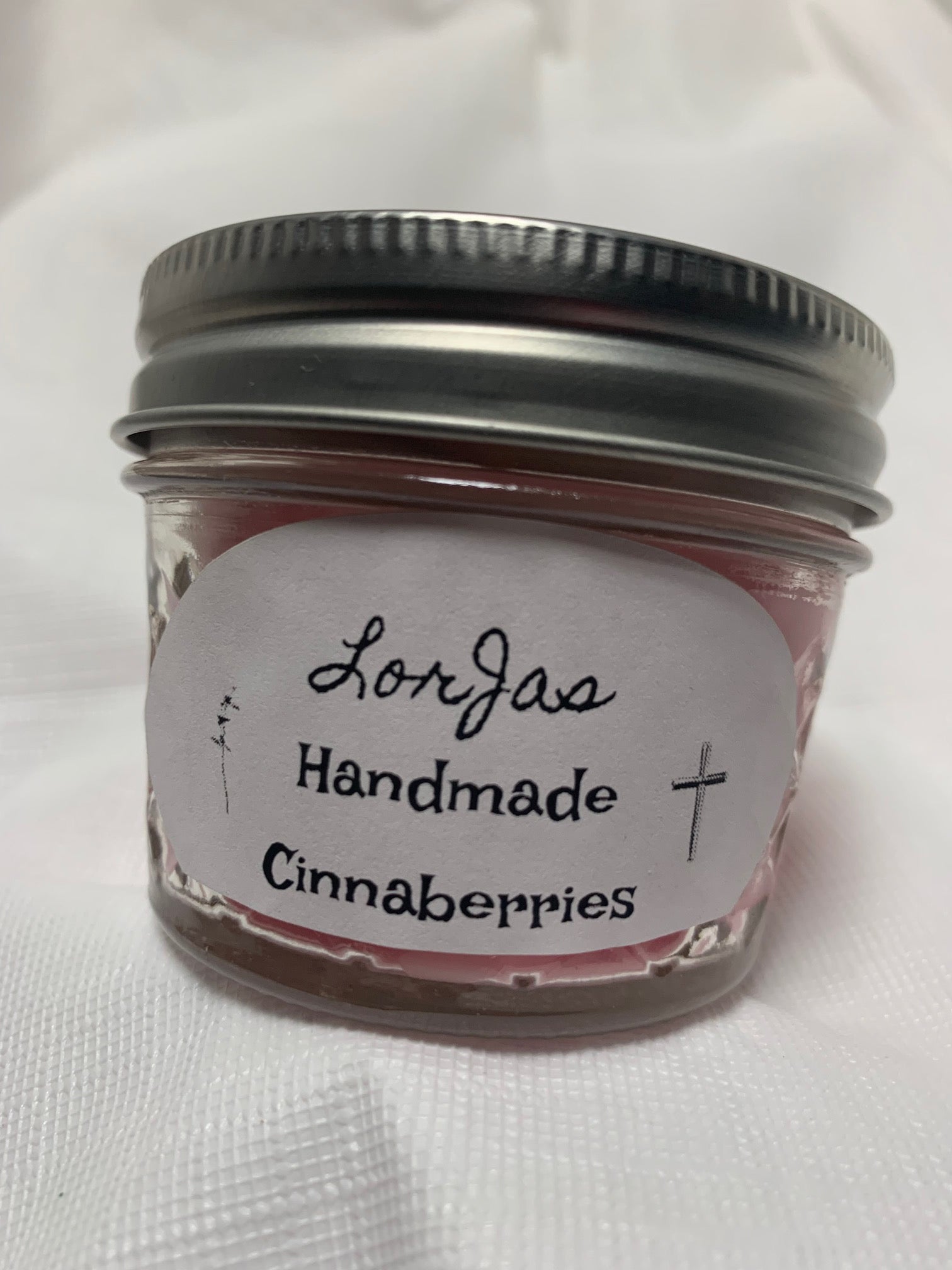 Jar of LorJas Handmade 'Cinnaberries' scented organic soy candle with a label on a white background
