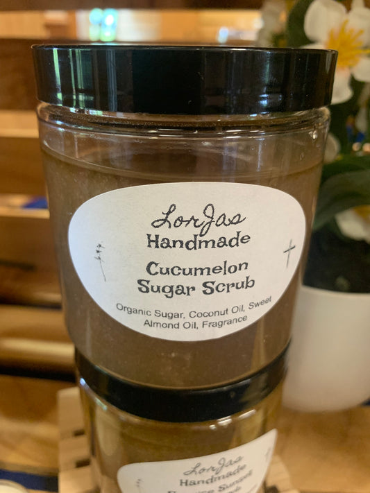Jar of LorJas Handmade 'Cucumelon' scented organic sugar scrub with a label on a blurred background