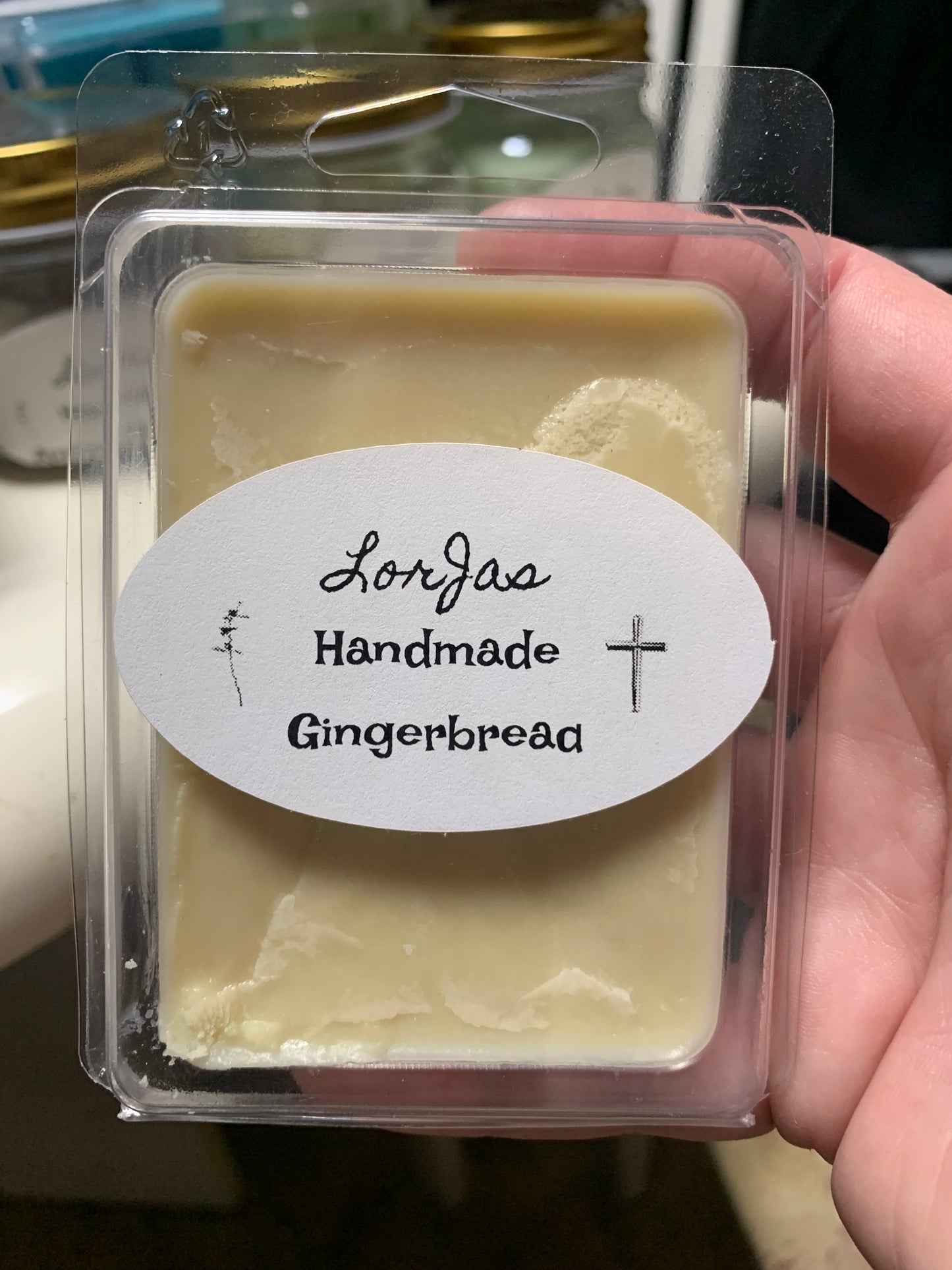 LorJas Handmade 'Gingerbread' scented organic goat milk soap in clear packaging with a branded label held by a hand.