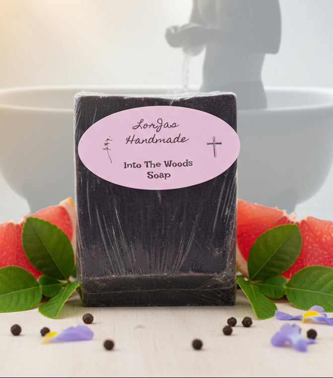Bar of soap with a pink label reading 'Lorjaa Handmade Into The Woods Soap' on a wooden surface.
