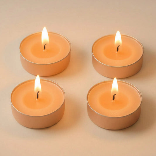 Four lit peach LorJas Handmade lightly scented soy tealights on a beige background.