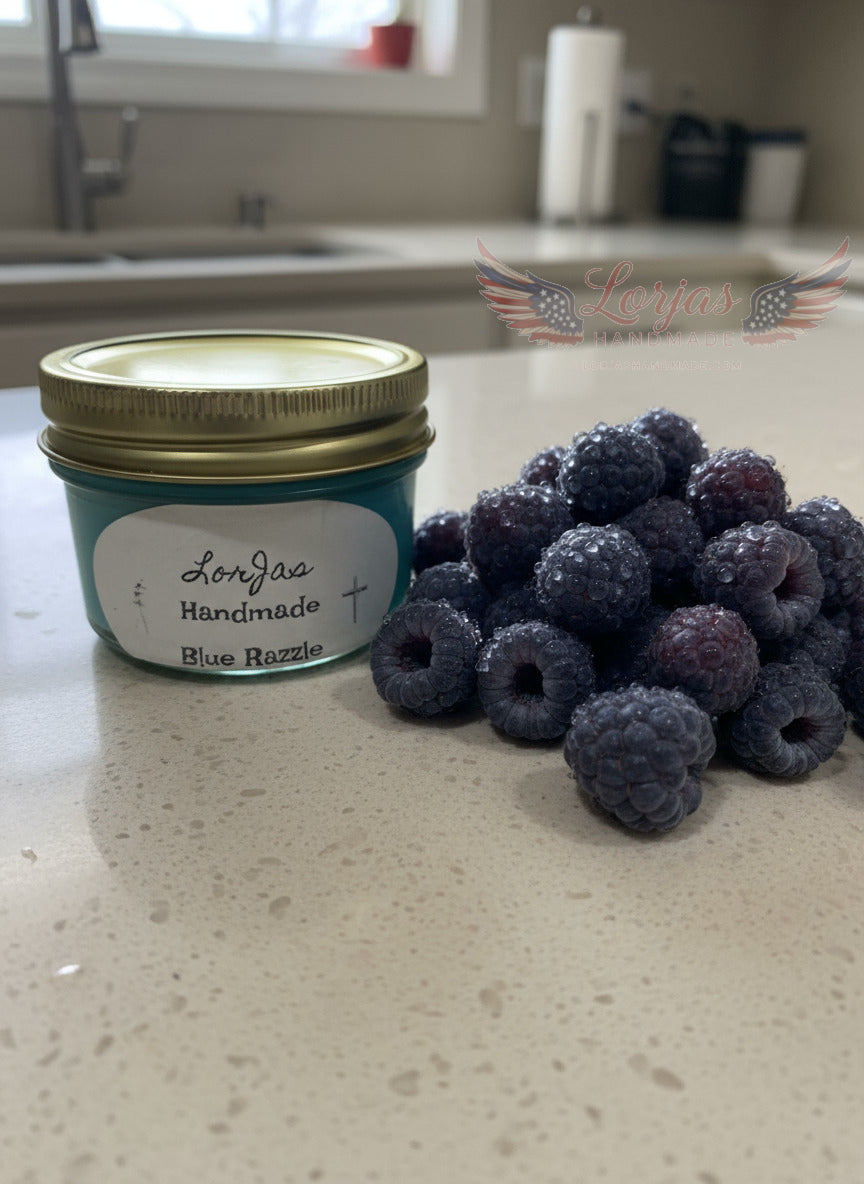 Lorjas Handmade 'Blue Razzle' scented organic soy candle on marble counter beside fresh raspberries