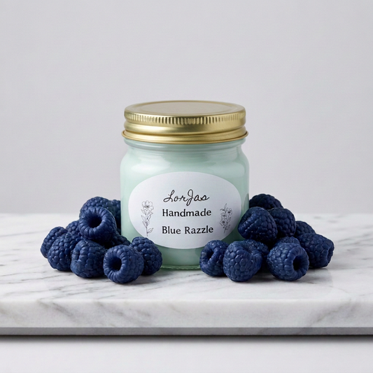 LorJas Handmade Blue Razzle lightly scented soy candle on marble counter beside fresh blue raspberries with blurred kitchen background.