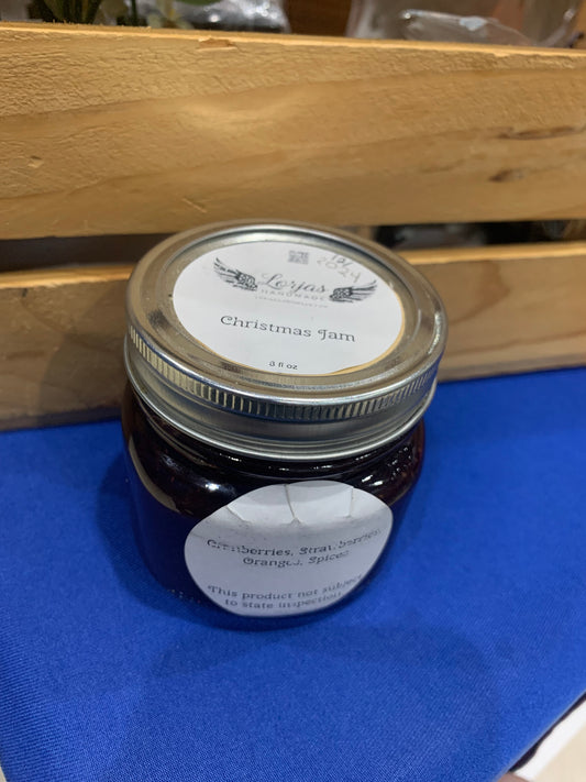 Jar of LorJas Handmade 'Christmas Jam' with a label on a blue tablecloth with a wooden background