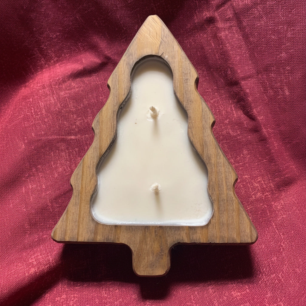 LorJas Handmade wooden Christmas tree-shaped candle filled with lightly scented soy candle on a red fabric background.