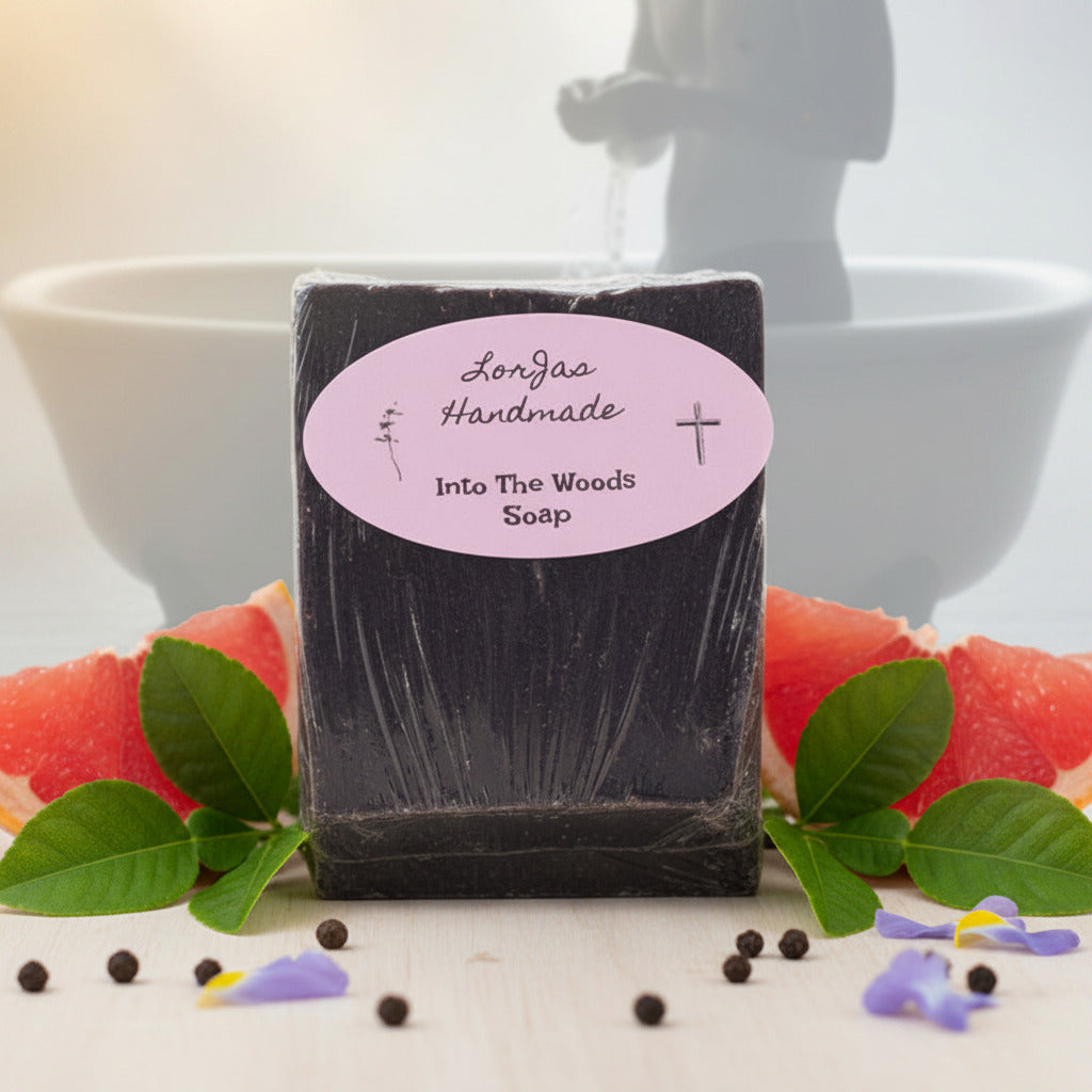 Lorjas Handmade Into The Woods Castile Soap on a granite surface with fresh mint, spices, herbs, and citrus slices with foggy bathhouse scene in the background.
