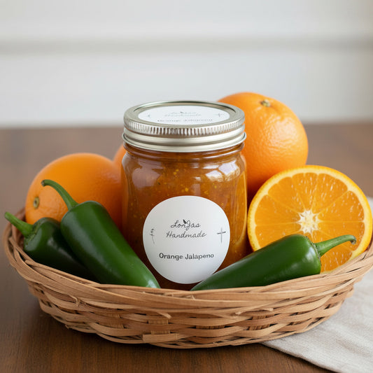 Lorjas Handmade Orange Jalapeno pepper jelly in basket with fresh jalapeño peppers and oranges on woodgrain counter