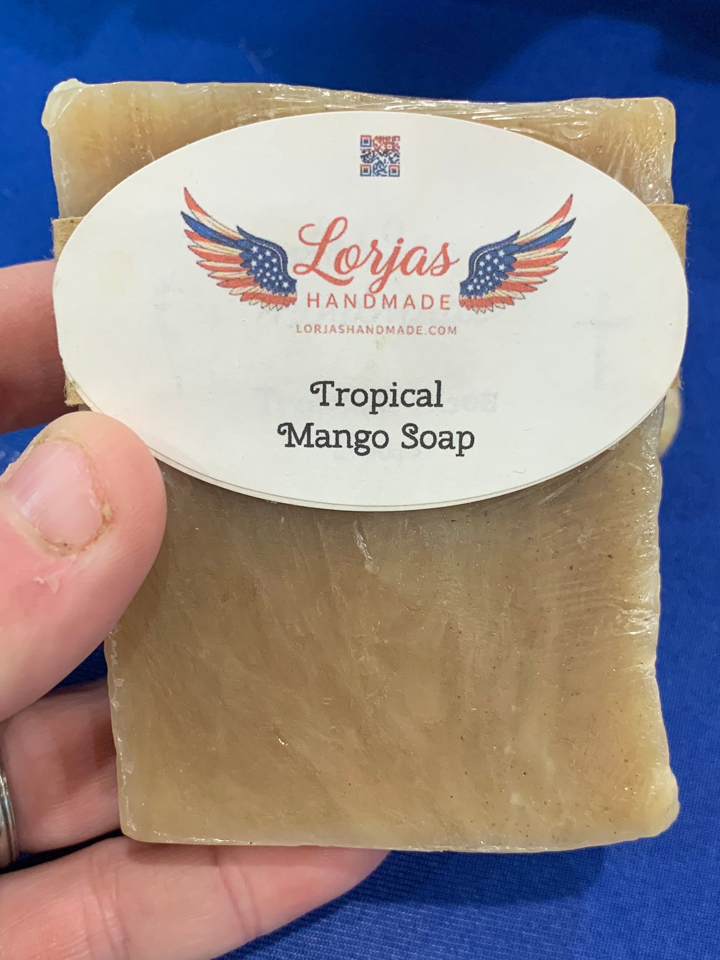 LorJas Handmade lightly scented tropical mango Castile soap on a blue background.