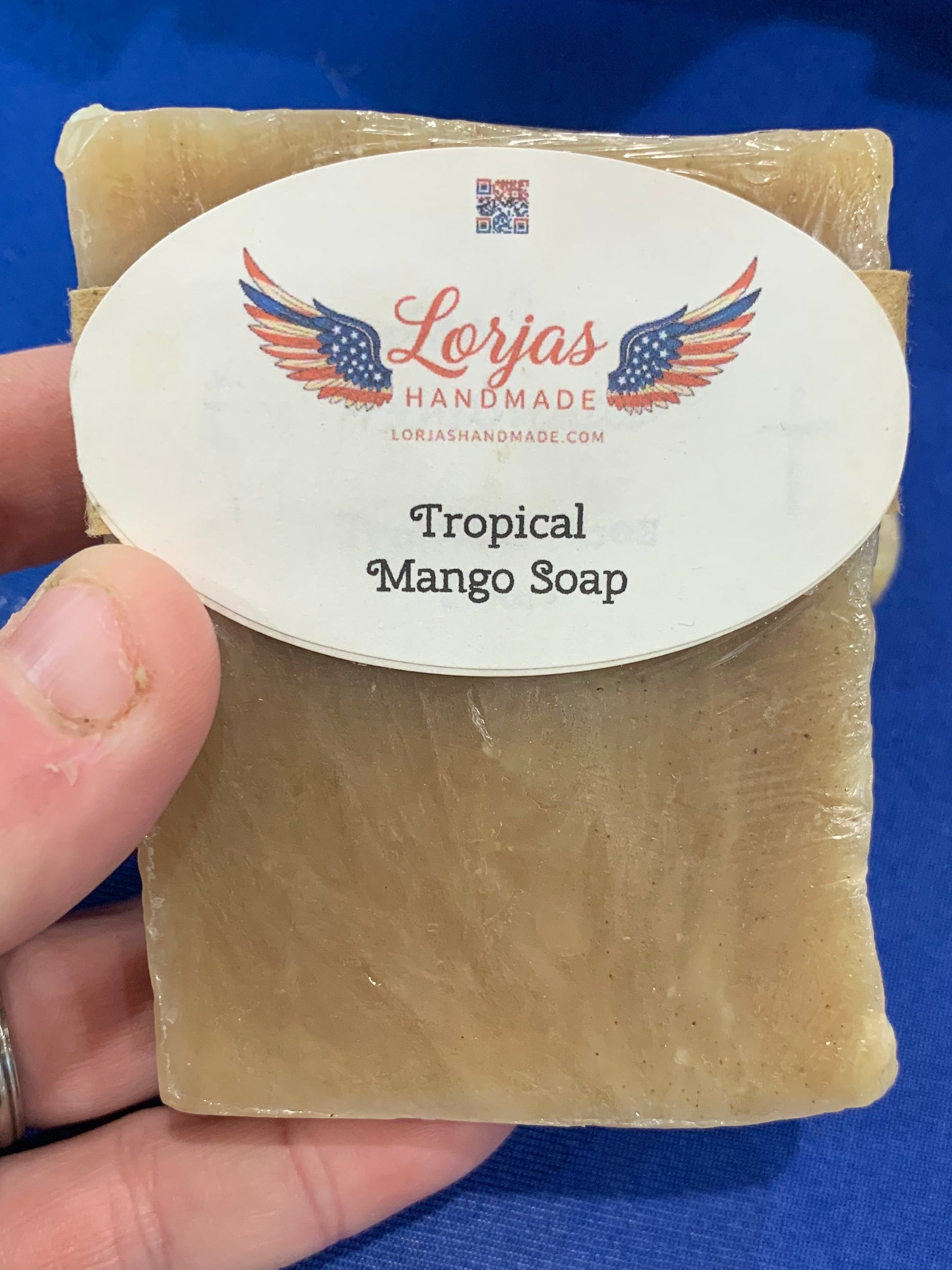 LorJas Handmade lightly scented tropical mango Castile soap on a blue background.