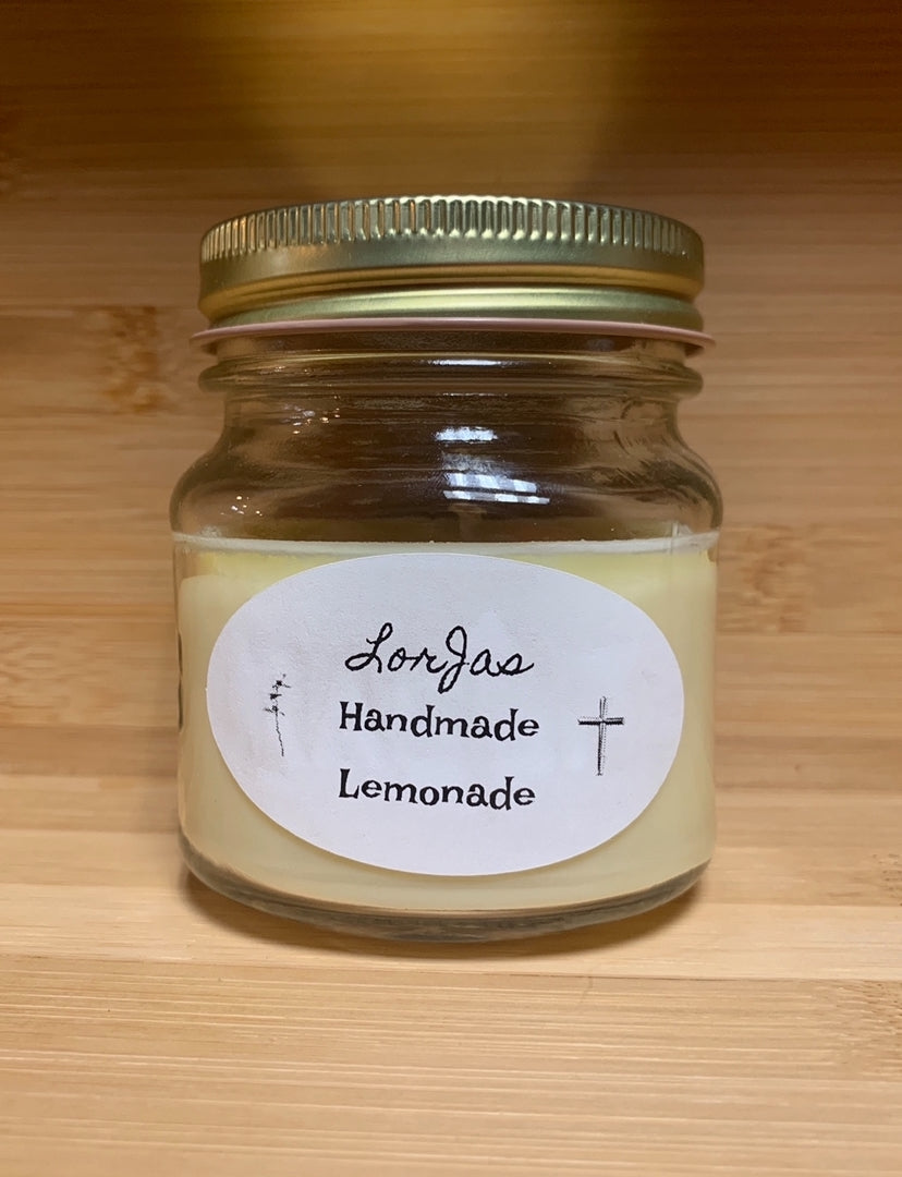 Jar of LorJas Handmade 'Lemonade' scented organic soy candle with a label on a wooden surface