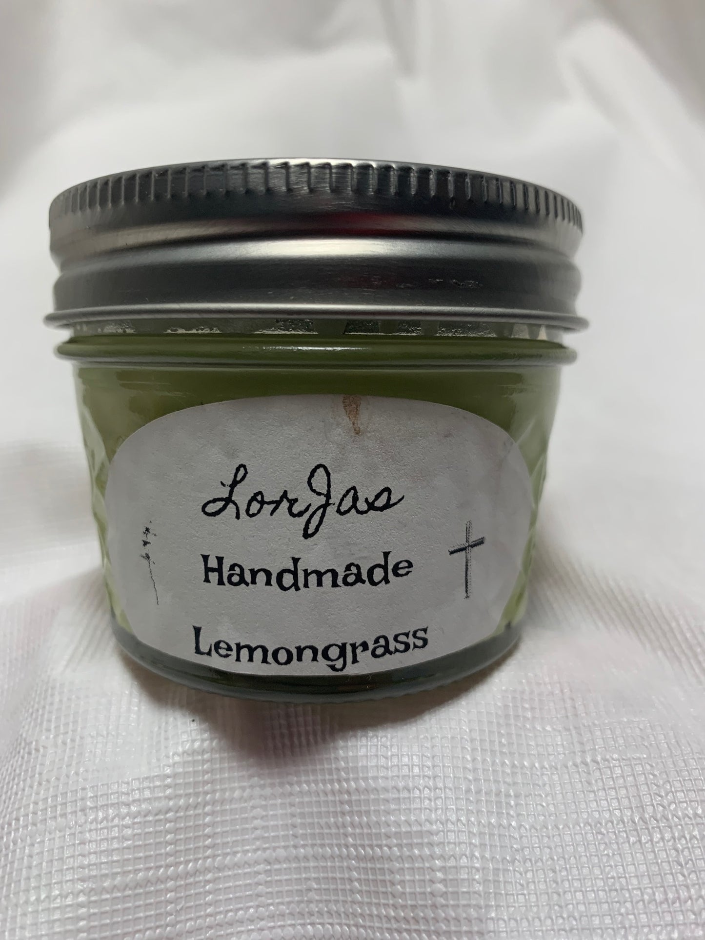 Jar of LorJas Handmade 'Lemongrass' scented organic soy candle with a label on a white background