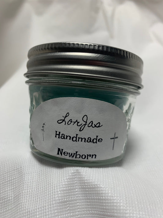 Jar of LorJas Handmade 'Newborn' scented organic soy candle with a label on a white background