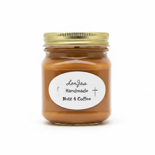 A glass jar candle with a gold metal lid and a white oval label reading 'LorJas Handmade Nutz 4 Coffee', filled with a warm caramel-brown wax, set against a plain white background.