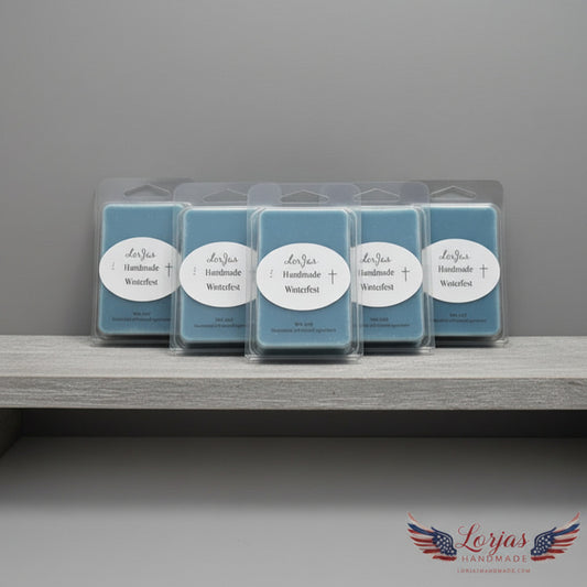 Five blue LorJas Handmade Winterfest lightly scented soy wax melts on a wooden shelf with a gray backdrop featuring LorJas Handmade brand logo.
