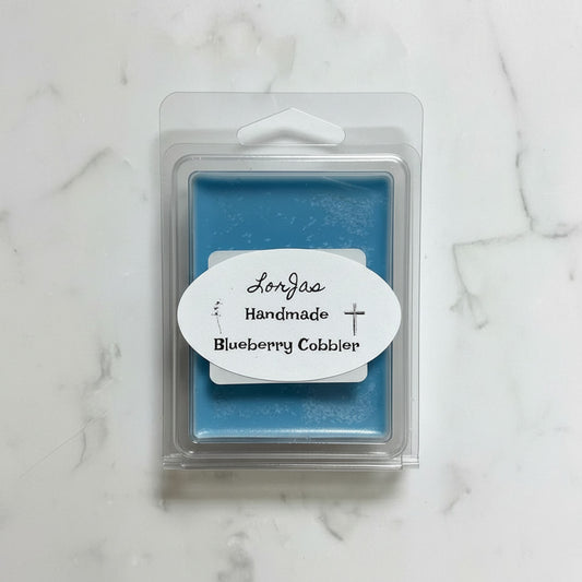 LorJas Handmade 'Blueberry Cobller' scented organic soy wax melt in clear branded packaging on a marble surface