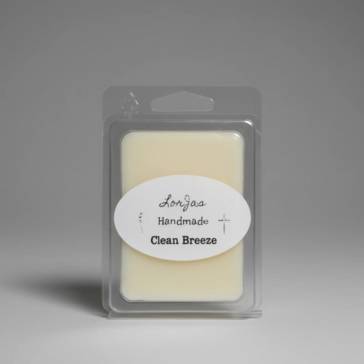 A packaged wax melt in a clear plastic clamshell package with a white oval label reading 'LorJas Handmade Clean Breeze' on a neutral gray background.