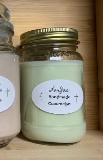 Two jars of LorJas Handmade 'Cucumelon' scented organic soy candles with labels on a wooden surface