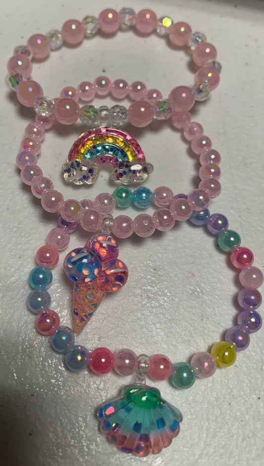 Three colorful beaded childrens' bracelets set on a white surface