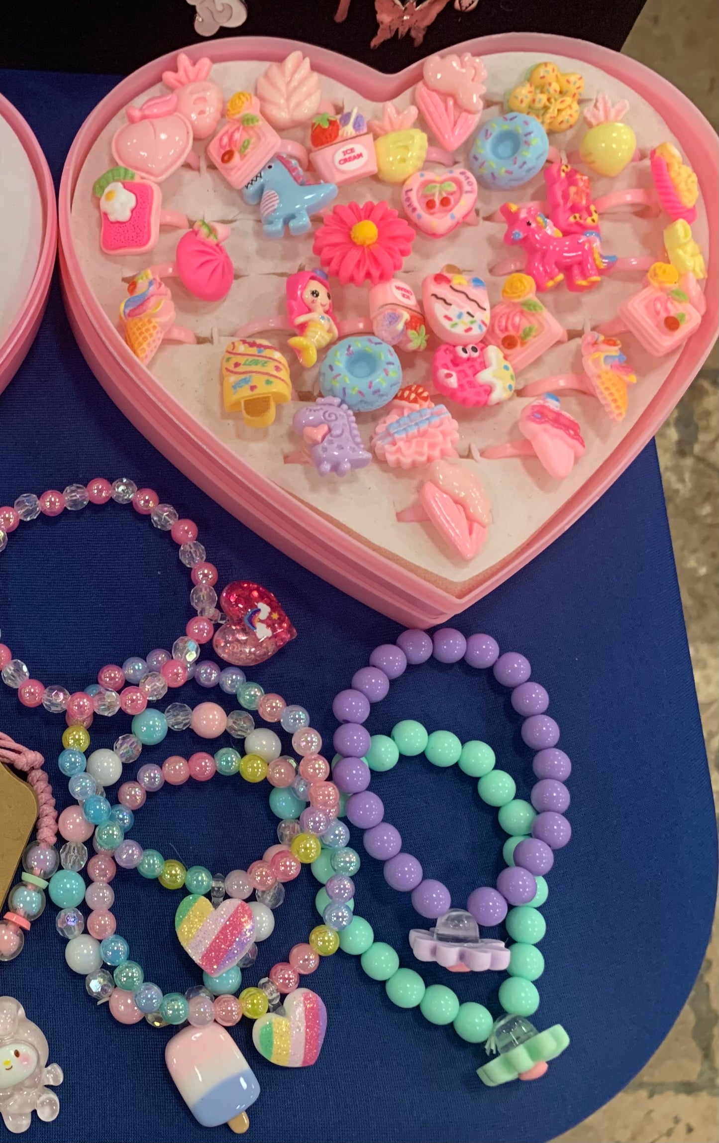 Colorful jewelry set with heart-shaped box on a blue surface