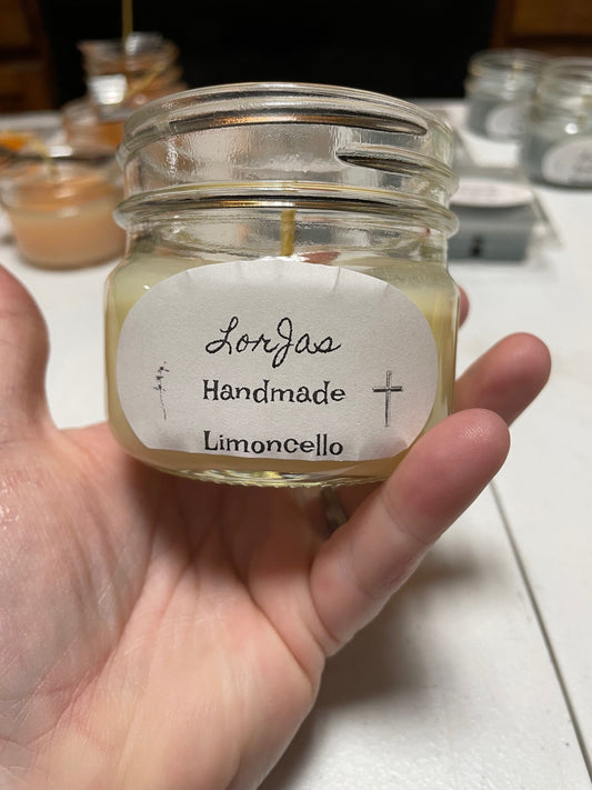 LorJas Handmade 'Limoncello' scented organic soy candle jar held by a hand with a blurred background