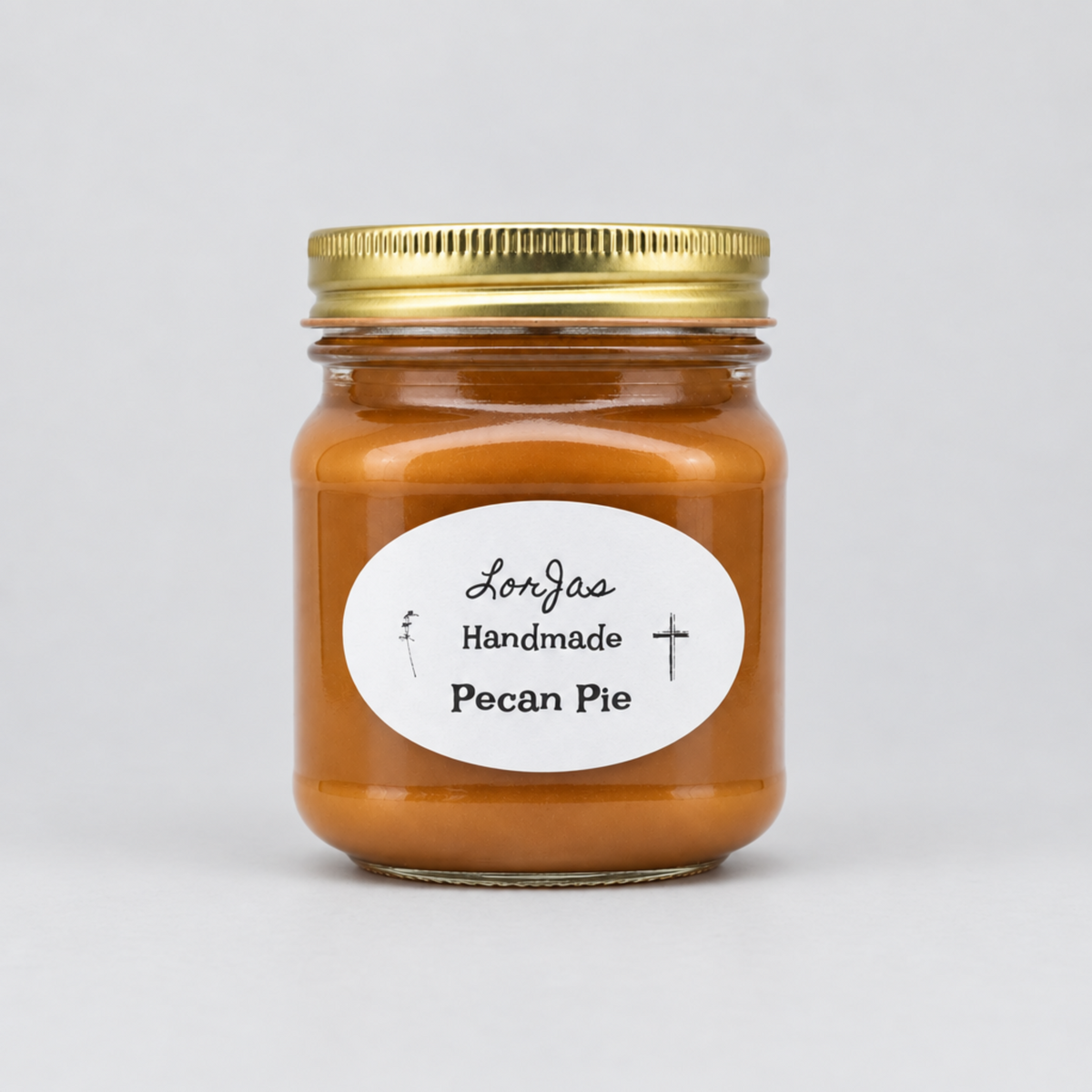 A glass jar filled with pecan pie lightly scented soy candle, sealed with a gold metal lid and featuring a white oval label that reads 'Lor'Jas Handmade Pecan Pie' on a light gray background.